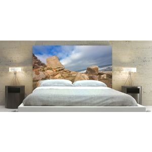 Bedroom with a large bed, stone-themed headboard, and two bedside tables with lamps.