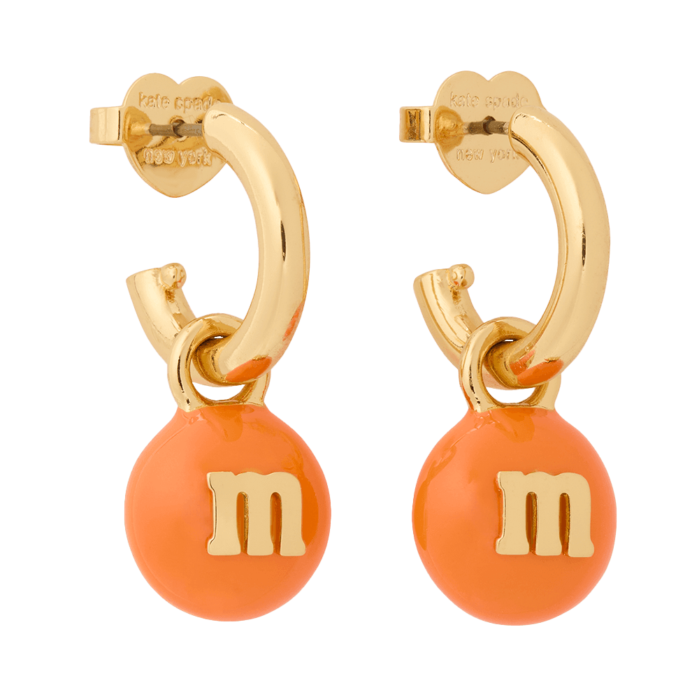 Gold hoop earrings with orange M&M charms designed by Kate Spade New York.